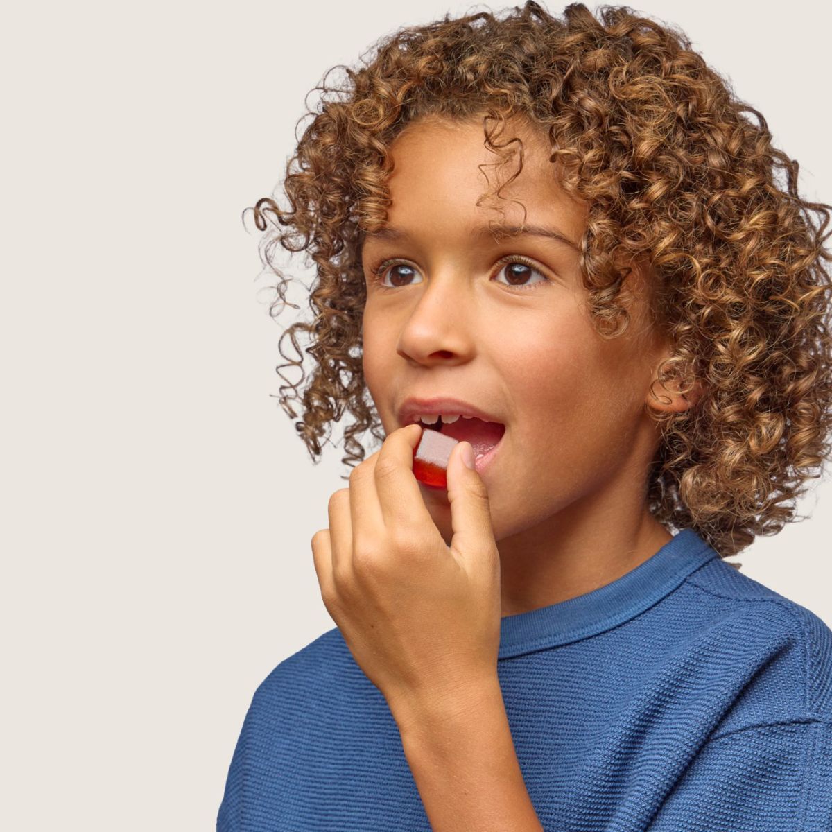 A child enjoying a Stasis Kids gummy.