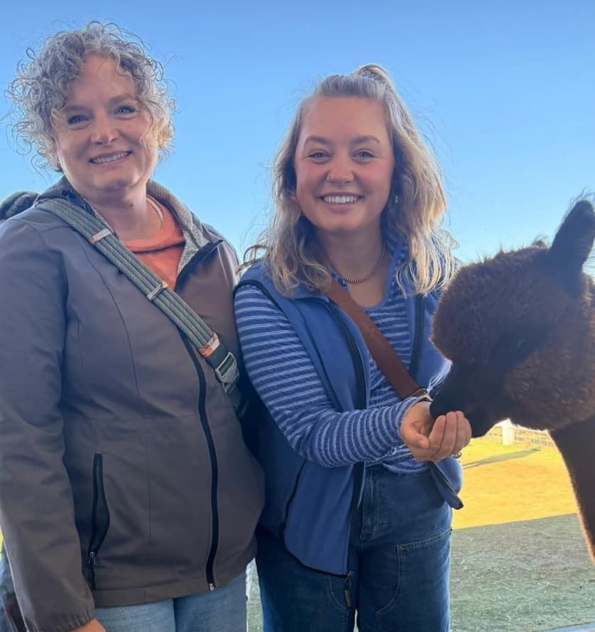 Guests feeding an alpaca at Pasture Palooza