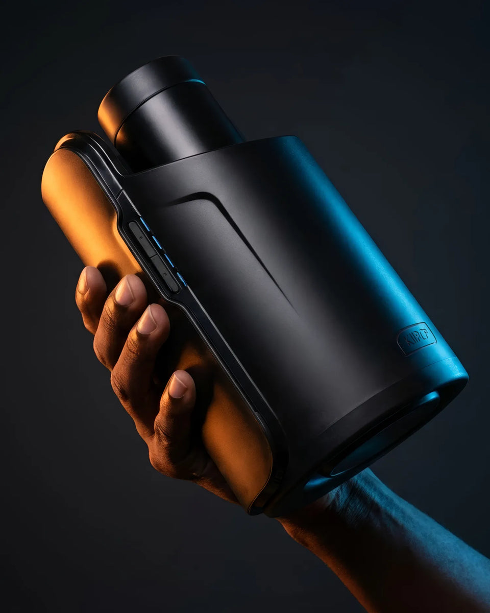 Original Kiiroo Keon held in a hand, lit in blue and amber